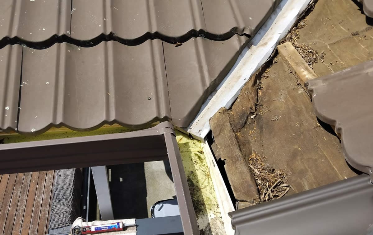 Damaged tiles removed, exposing the battens and underlay