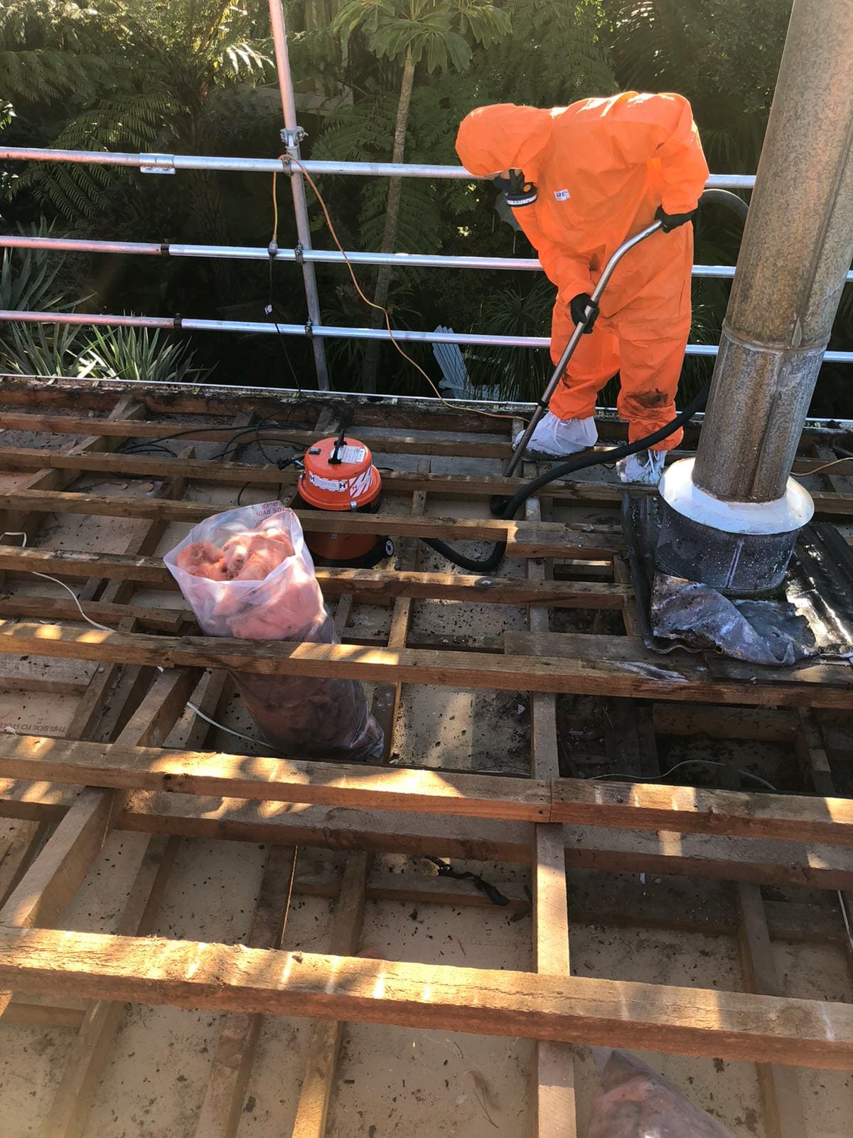 Crew member in protective gear clearing the roof framing