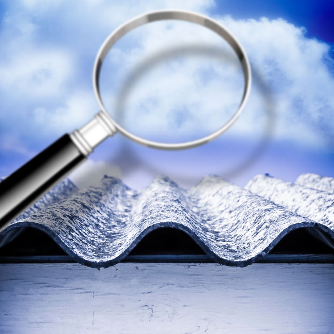 Magnifying glass over corrugated asbestos cement roofing, representing asbestos testing