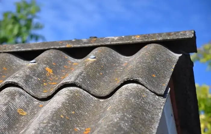 Close-up of a weathered asbestos roof with moss growth